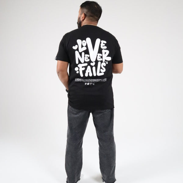 LOVE NEVER FAILS TEE BLACK